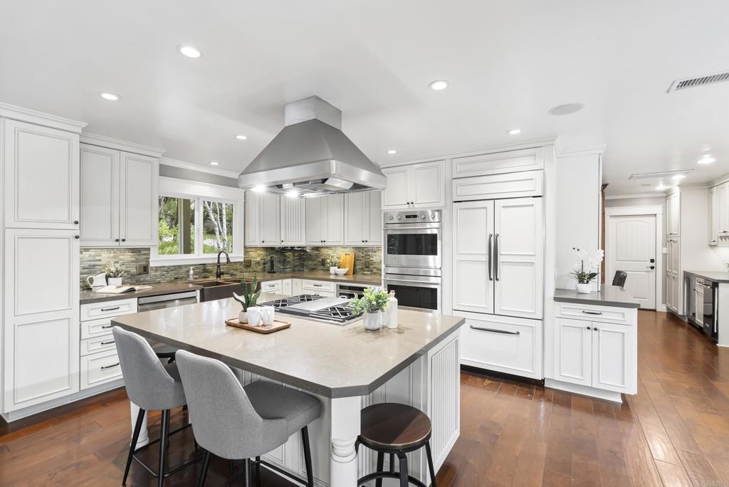 4847 Vita Road La Mesa, CA 91941 - Photo 19 of 73 a kitchen with stainless steel appliances kitchen island granite countertop a dining table chairs and white cabinets
