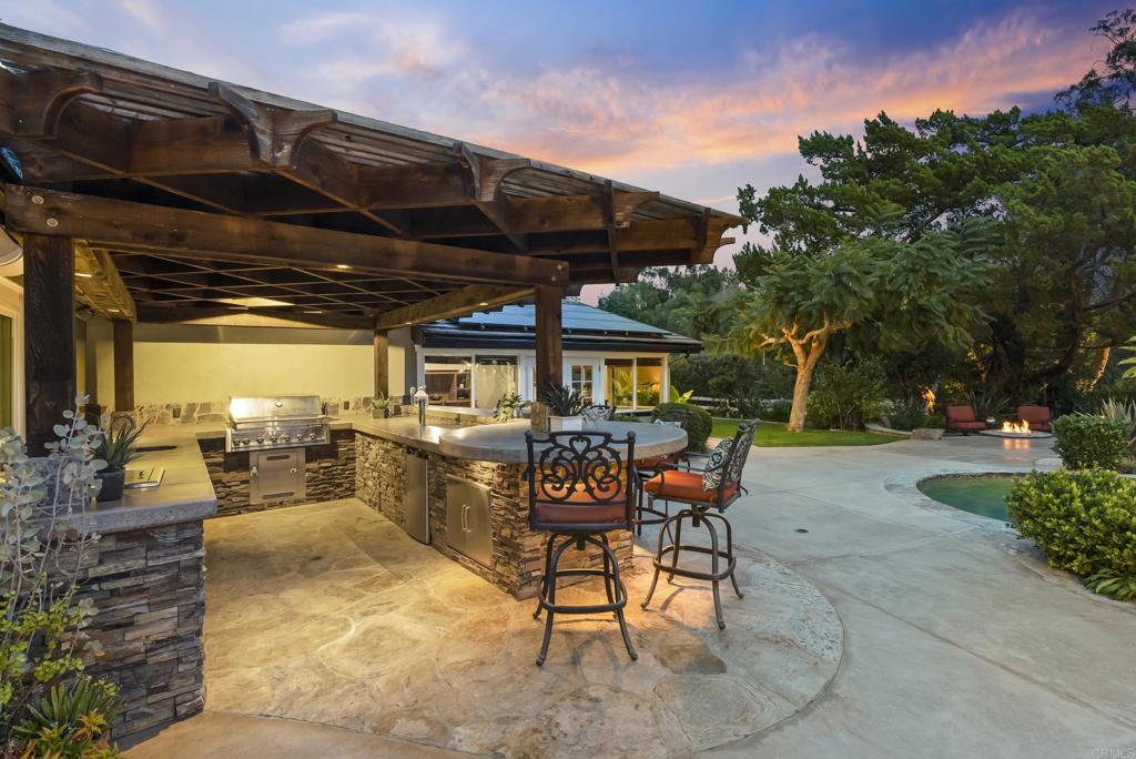 4847 Vita Road La Mesa, CA 91941 - Photo 55 of 73 a view of a patio with a table and chairs under an umbrella with a barbeque