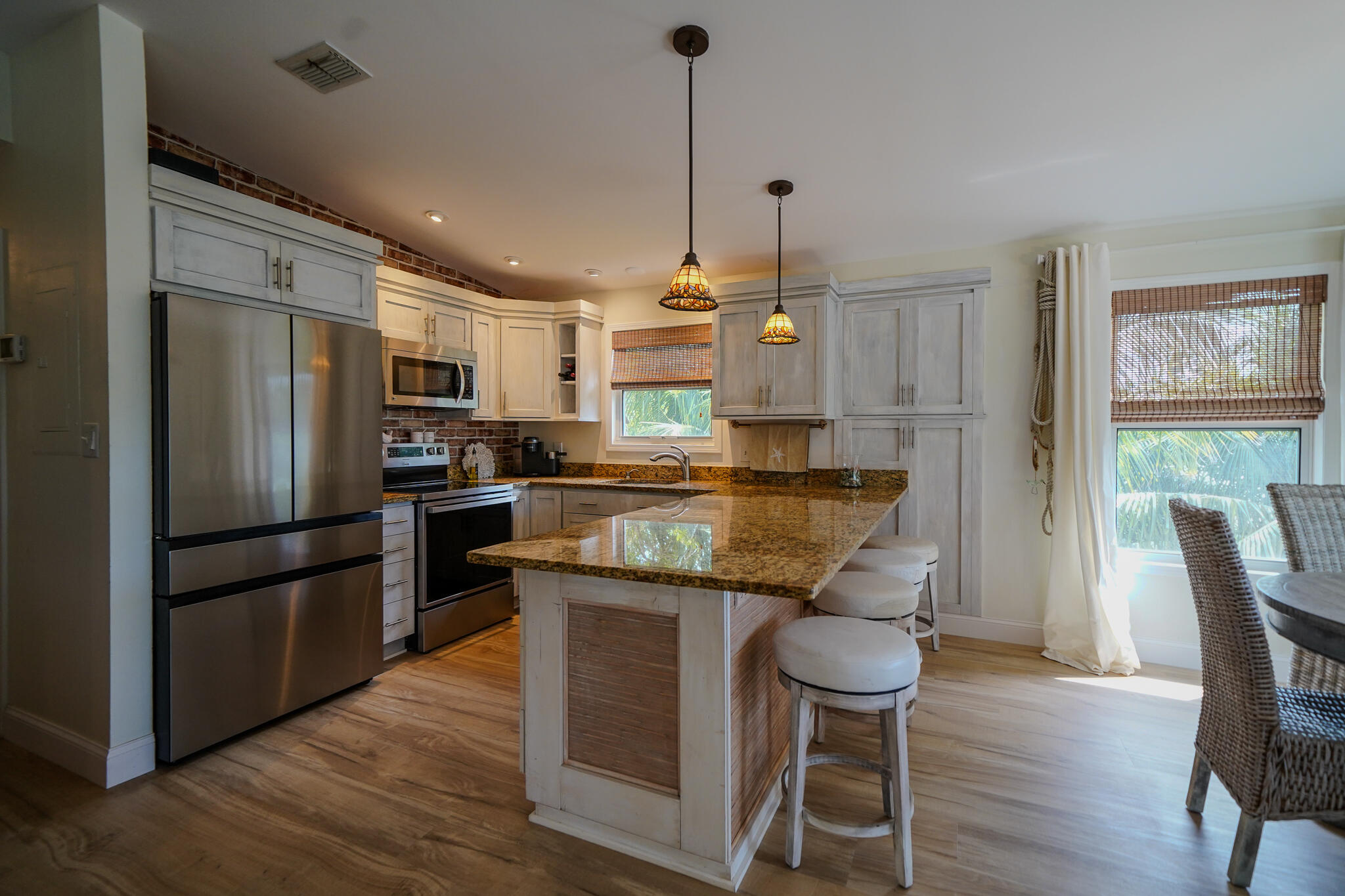 21 Corrine Place Key Largo, FL 33037 - Photo 5 of 46 a kitchen with granite countertop a refrigerator a stove a sink dishwasher a dining table and chairs with wooden floor