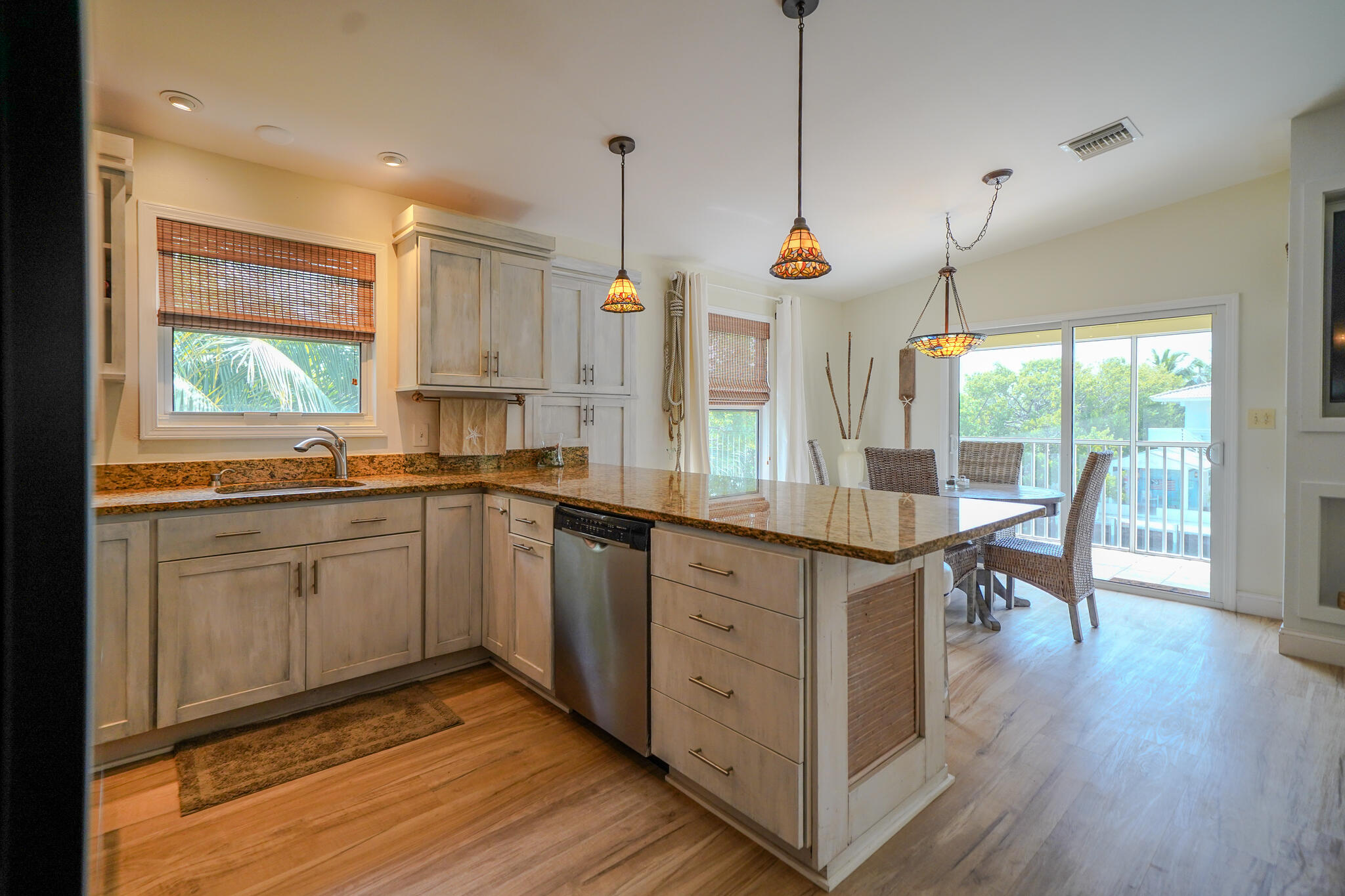 21 Corrine Place Key Largo, FL 33037 - Photo 7 of 46 a kitchen with stainless steel appliances granite countertop wooden floors sink and cabinets