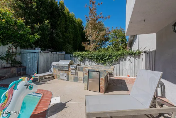 a view of a patio with table and chairs potted plants and large tree
