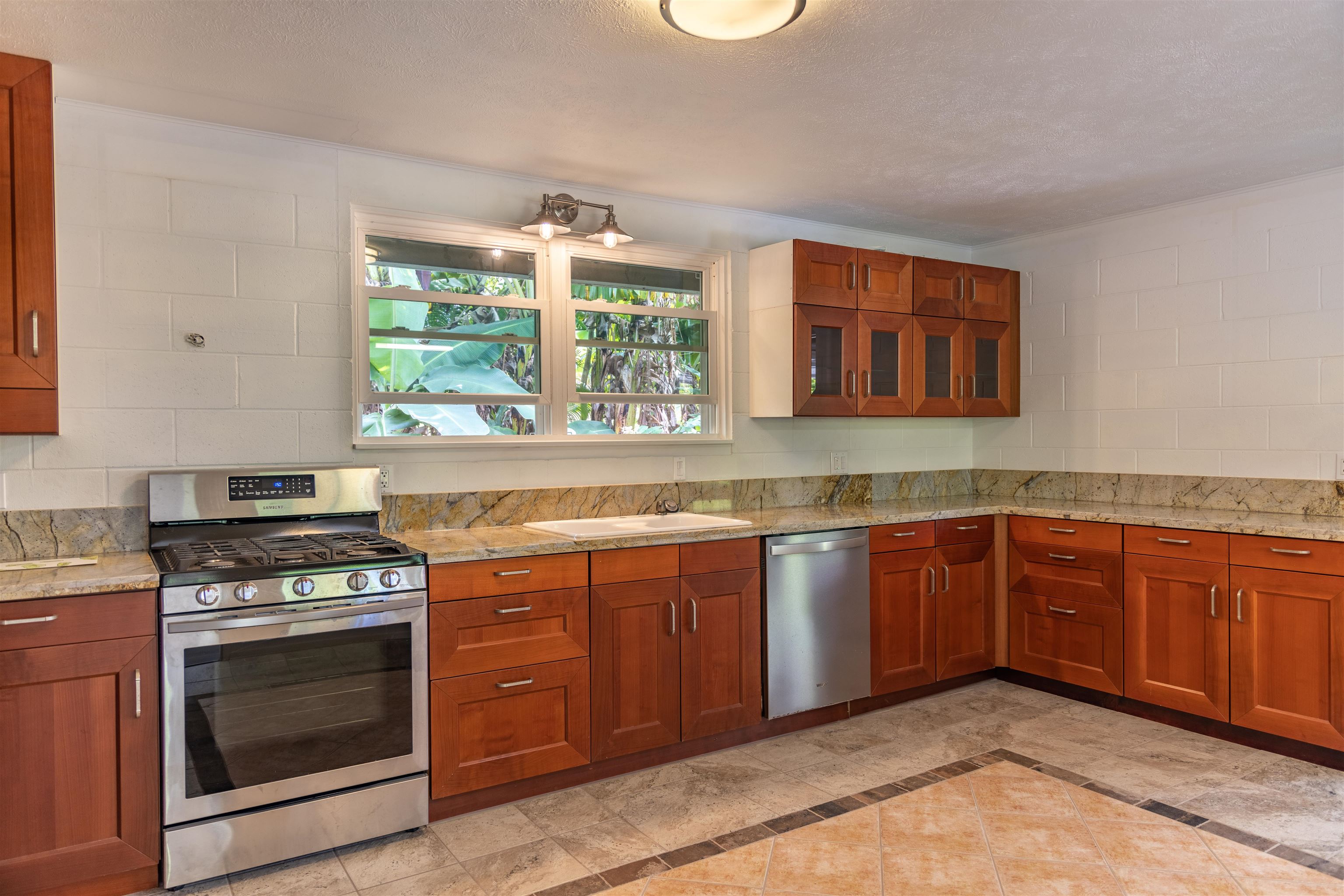 1660 West Kuiaha Road, Unit A Haiku, HI 96708 - Photo 8 of 30 a kitchen with stainless steel appliances granite countertop a stove and a sink