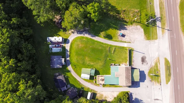 an aerial view of a house with swimming pool and large trees