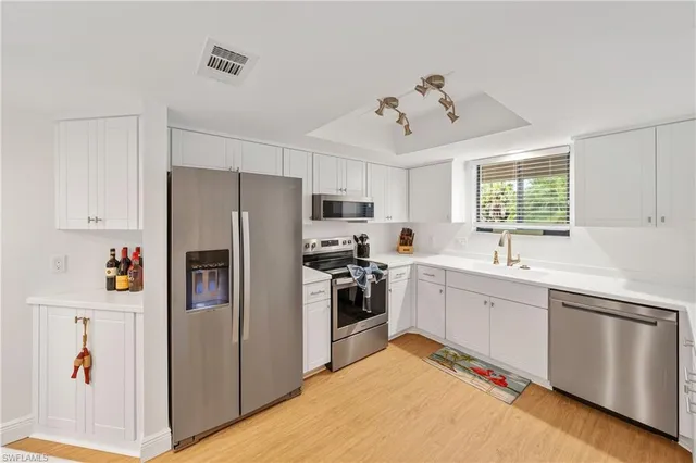 a kitchen with stainless steel appliances granite countertop a refrigerator and a stove top oven