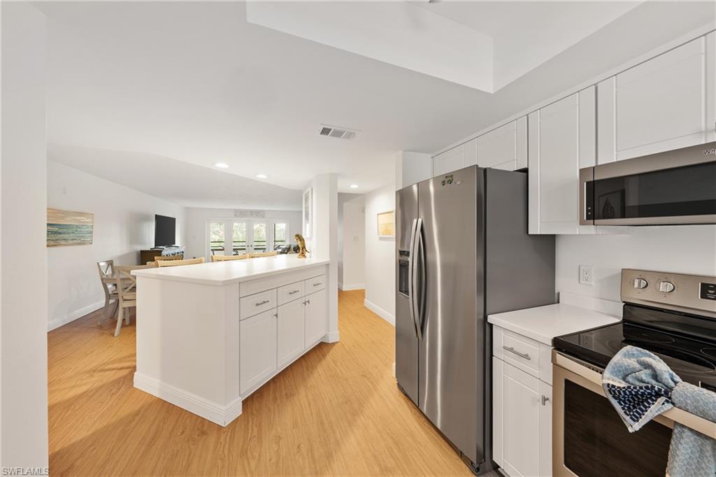 801 Islamorada Boulevard, Unit 22B Punta Gorda, FL 33955 - Photo 12 of 48 a kitchen with stainless steel appliances white cabinets and a refrigerator