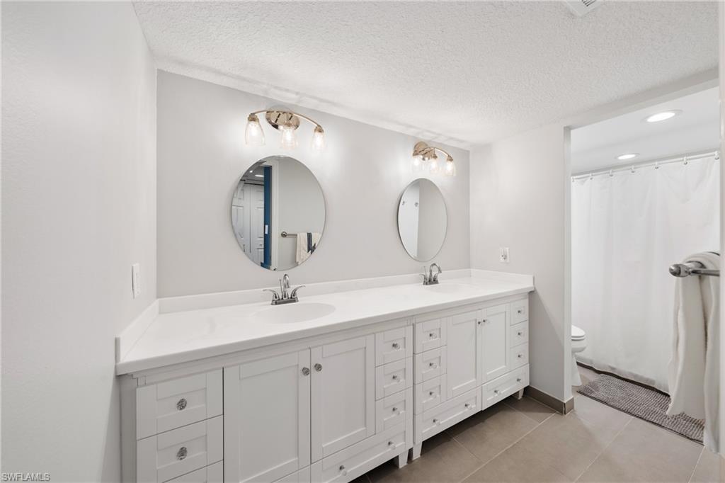 801 Islamorada Boulevard, Unit 22B Punta Gorda, FL 33955 - Photo 22 of 48 a bathroom with a double vanity sink and a mirror