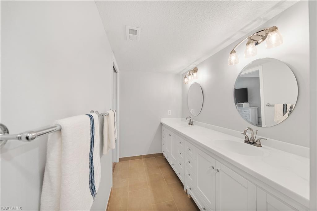 801 Islamorada Boulevard, Unit 22B Punta Gorda, FL 33955 - Photo 23 of 48 a bathroom with a double vanity sink and mirror