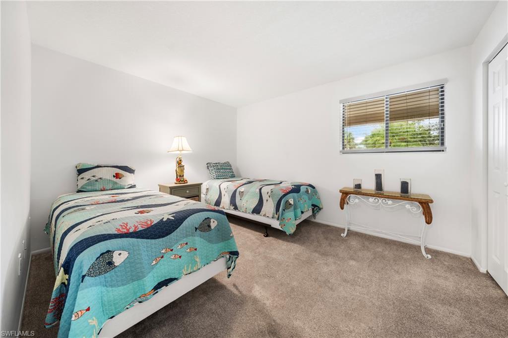 801 Islamorada Boulevard, Unit 22B Punta Gorda, FL 33955 - Photo 24 of 48 a bedroom with two beds and a couch