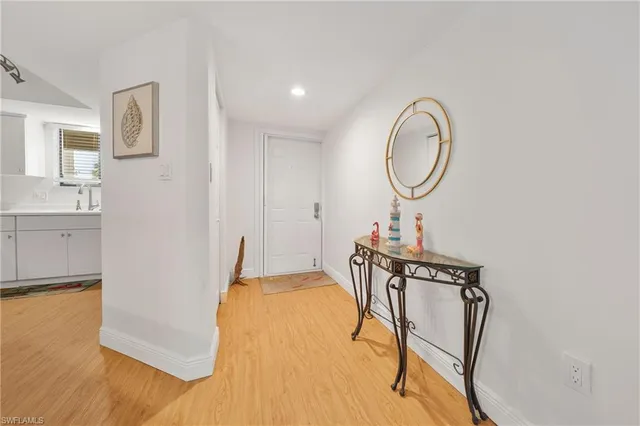 a living room with stainless steel appliances a table chairs and a refrigerator