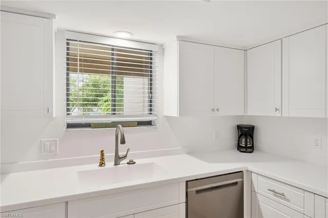 a kitchen with stainless steel appliances a refrigerator a stove and white cabinets