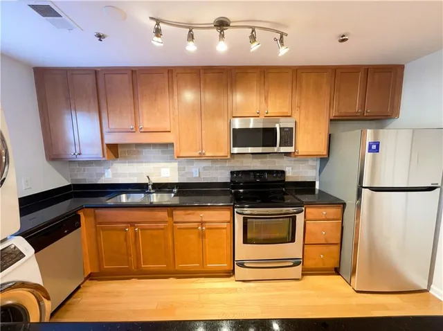 a spacious bedroom with a bed and a chandelier