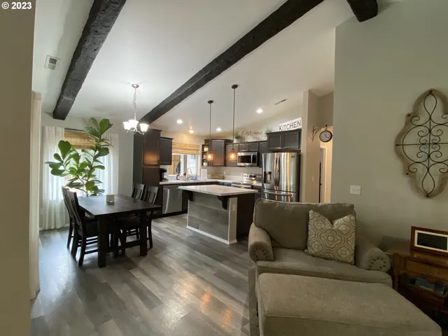 a living room with furniture and a dining table with kitchen view