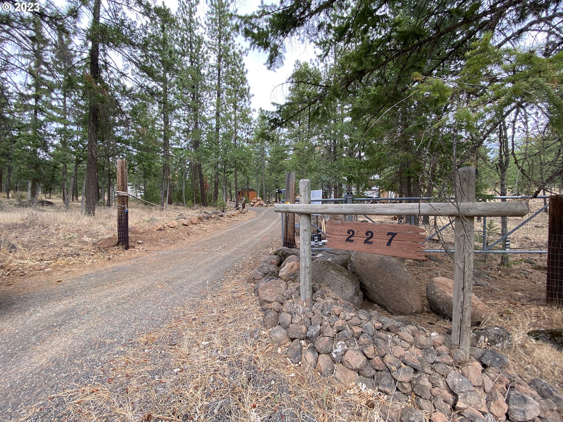 227 Locust Lane Goldendale, WA 98620 - Photo 41 of 48 a view of a backyard with wooden fence and large trees