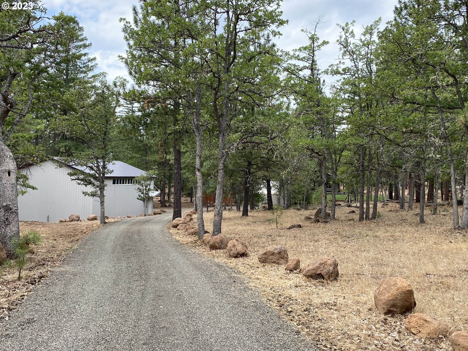 227 Locust Lane Goldendale, WA 98620 - Photo 45 of 48 a backyard of a house with large trees and covered with wooden fence