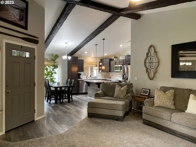 a living room with furniture kitchen view and a chandelier