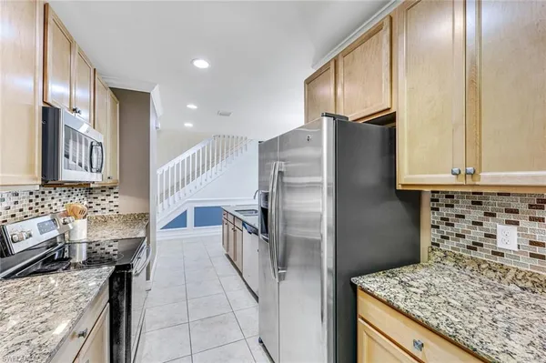 a kitchen with granite countertop a refrigerator and a stove
