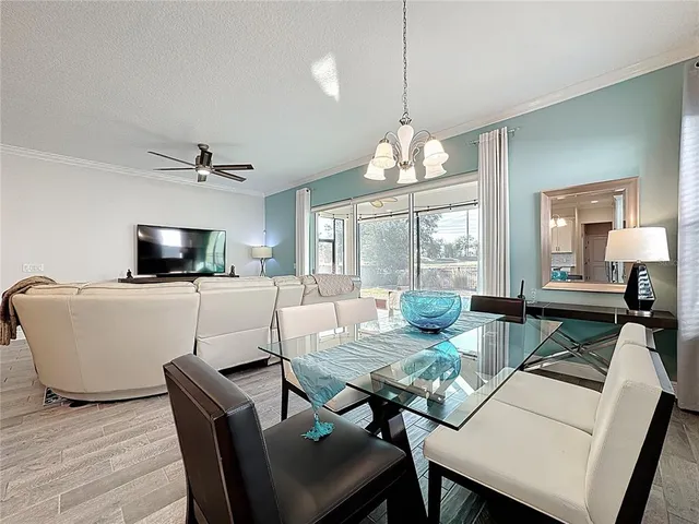 a living room with furniture a flat screen tv and kitchen view