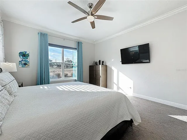 a bedroom with a bed and a flat tv screen on dresser