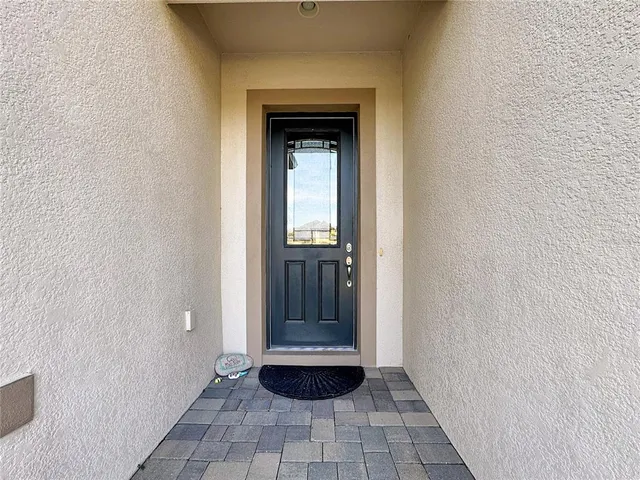 a view of a hallway with wooden floor and a living room