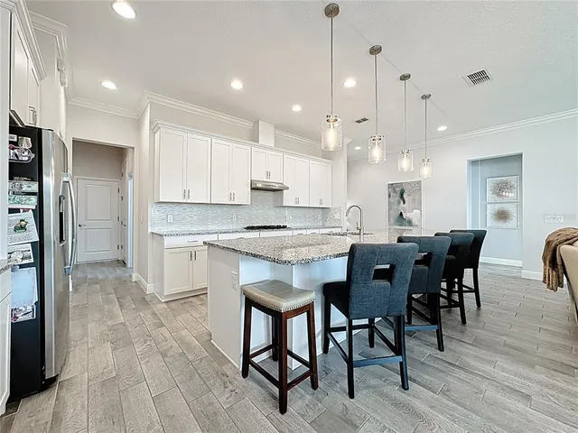 a kitchen with stainless steel appliances granite countertop a refrigerator and a stove top oven