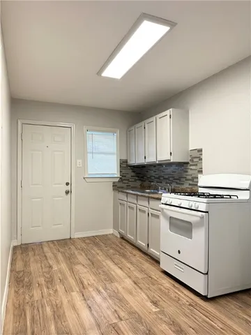 a kitchen with granite countertop white cabinets and white appliances