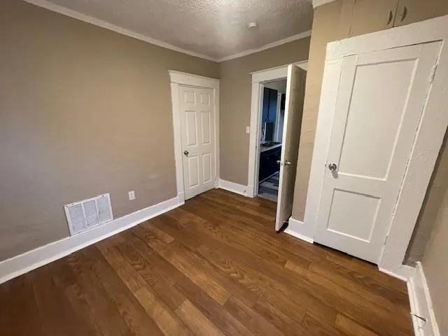 an empty room with wooden floor and closet