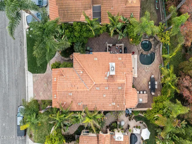 a view of a white house with a large outdoor space and sitting area
