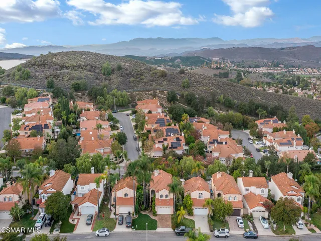 an aerial view of residential houses with outdoor space and trees