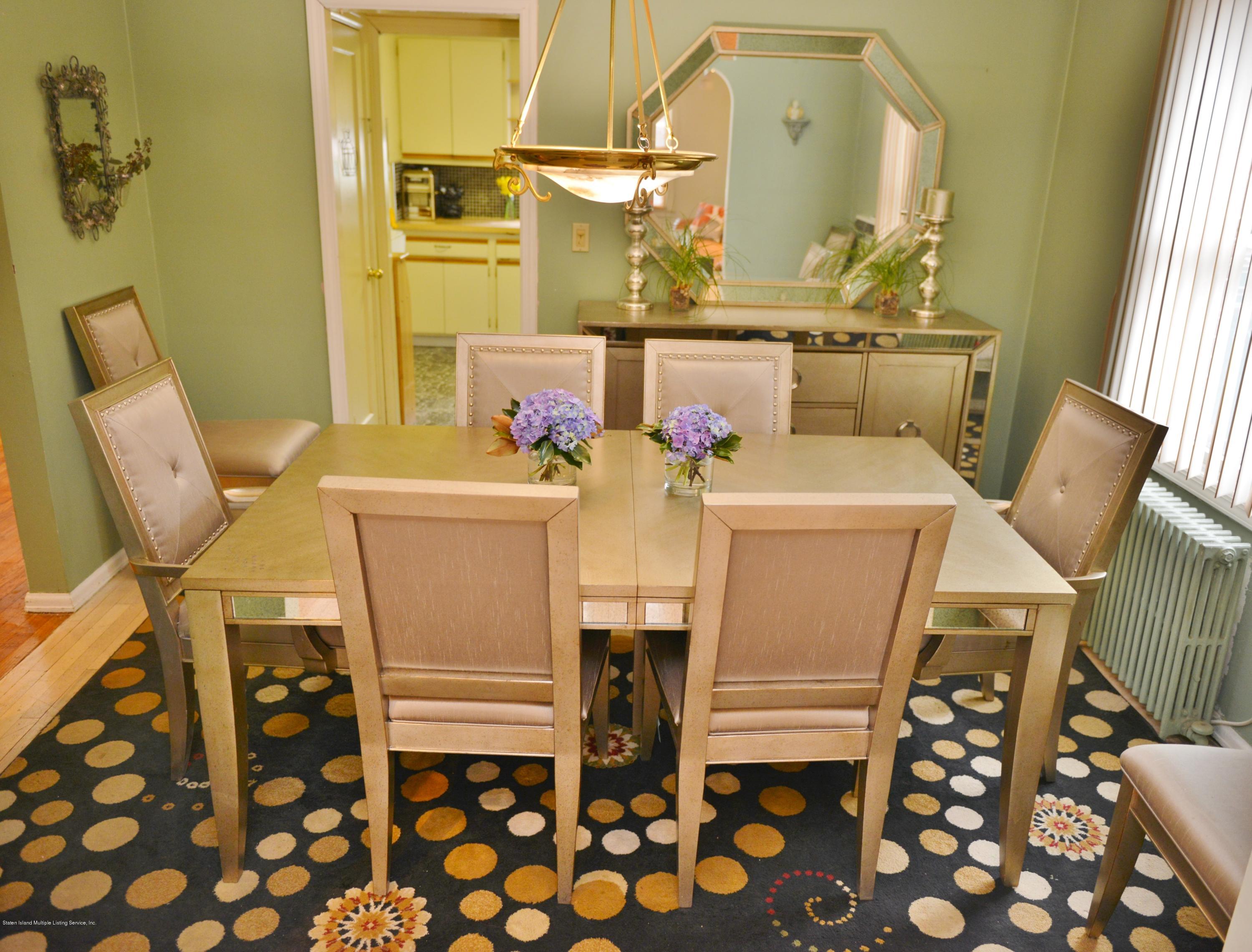 102 Governor Road Staten Island, NY 10314 - Photo 4 of 6 a room with stainless steel appliances a stove a table and chair