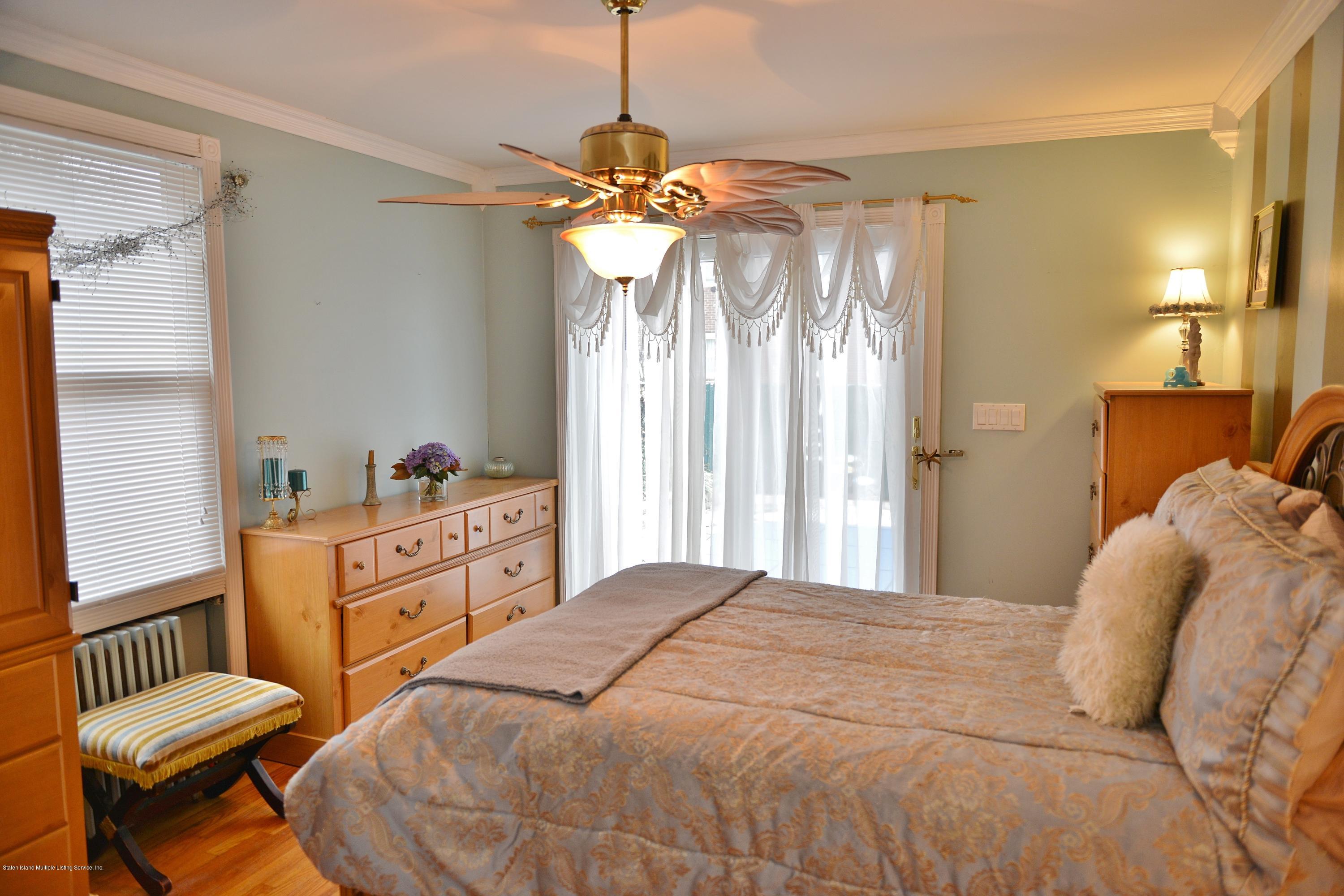 102 Governor Road Staten Island, NY 10314 - Photo 6 of 6 a bedroom with a bed and a chandelier