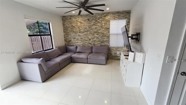 a living room with furniture and a floor to ceiling window