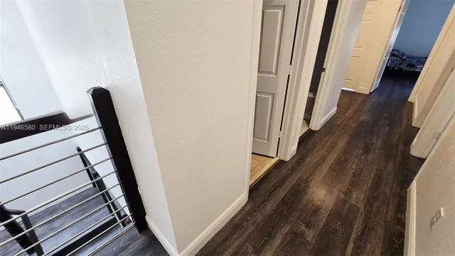 a bed sitting in a bedroom next to a flat tv screen on dresser and a wooden floor