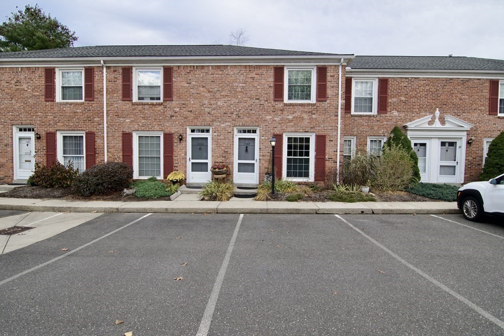 front view of a brick house with a yard