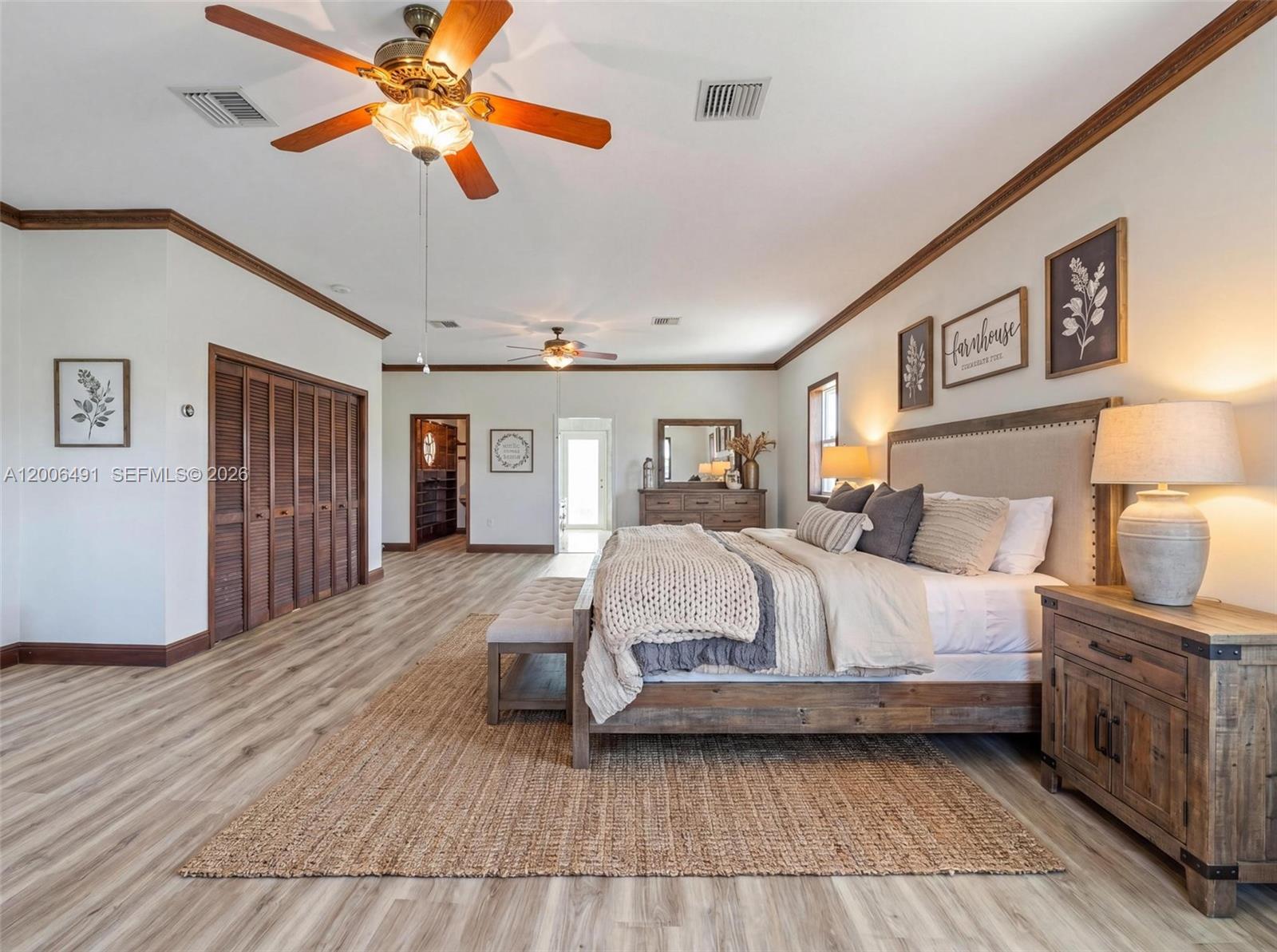 22275 Southwest 256th Street Homestead, FL 33031 - Photo 23 of 57 a bedroom with a large bed a chandelier and dresser