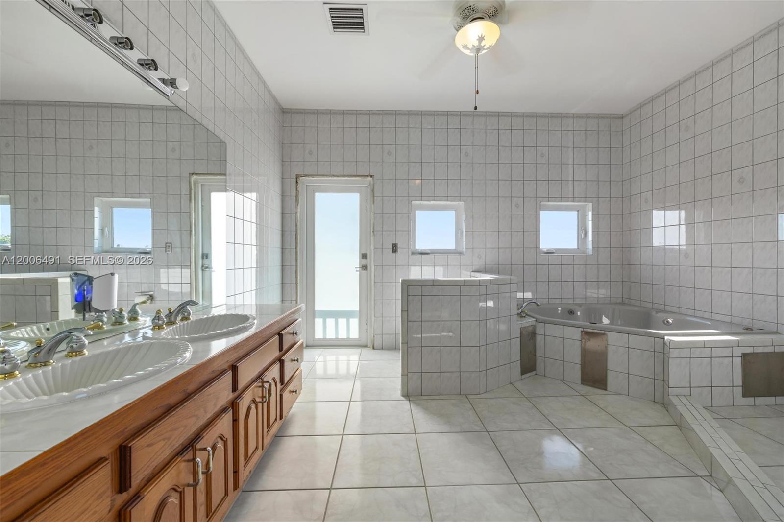 22275 Southwest 256th Street Homestead, FL 33031 - Photo 25 of 57 a spacious bathroom with a granite countertop sink a toilet a mirror and bathtub