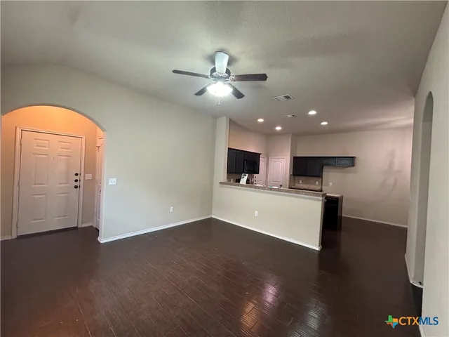 a view of empty room with wooden floor and window