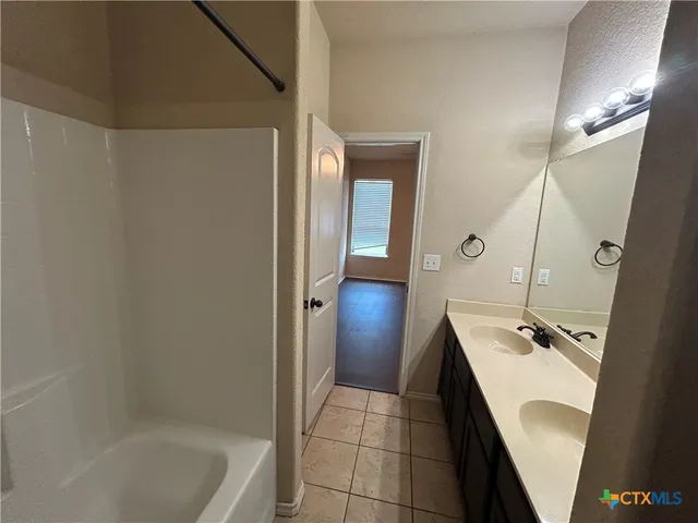 a bathroom with a tub sink and mirror
