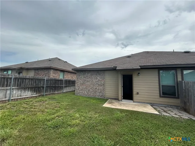 a view of a house with a yard and a large tree