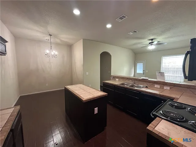 a kitchen with sink stove and cabinets