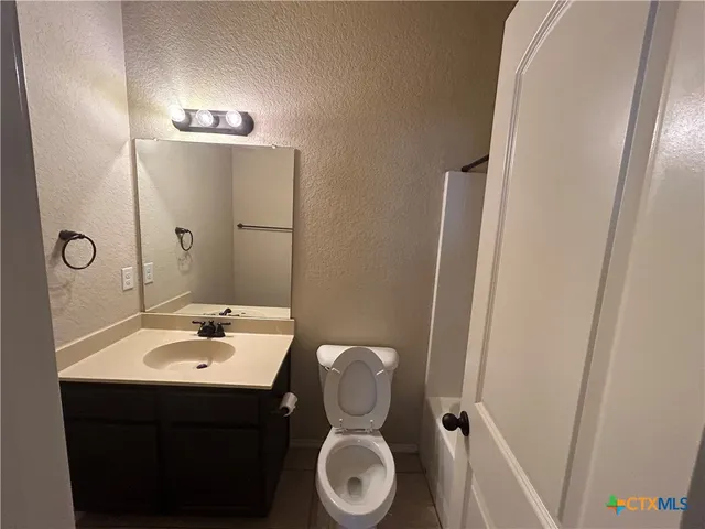 a bathroom with a sink toilet and mirror