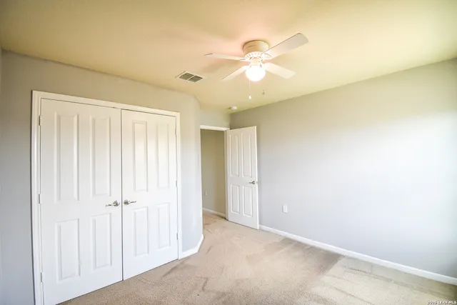 an empty room with a ceiling fan and a window