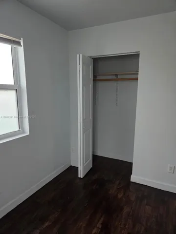 an empty room with wooden floor and closet