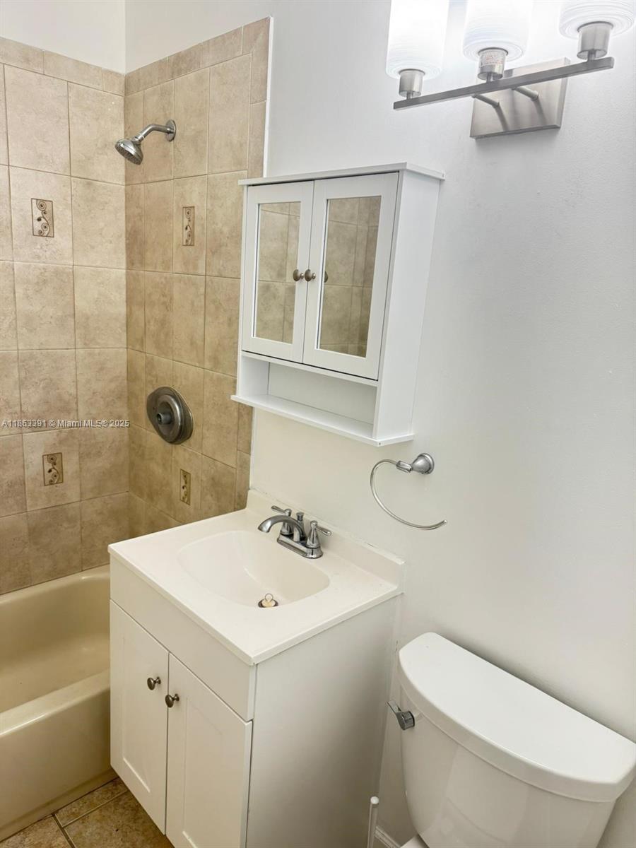 4351 Northeast 18th Avenue Pompano Beach, FL 33064 - Photo 14 of 18 a bathroom with a sink a toilet and shower