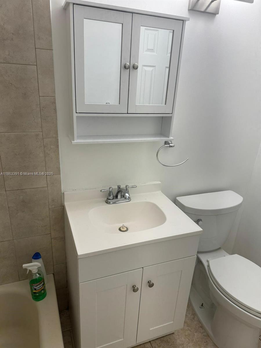 4351 Northeast 18th Avenue Pompano Beach, FL 33064 - Photo 15 of 18 a bathroom with a toilet sink and mirror