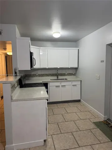 a kitchen with a stove top oven and cabinets
