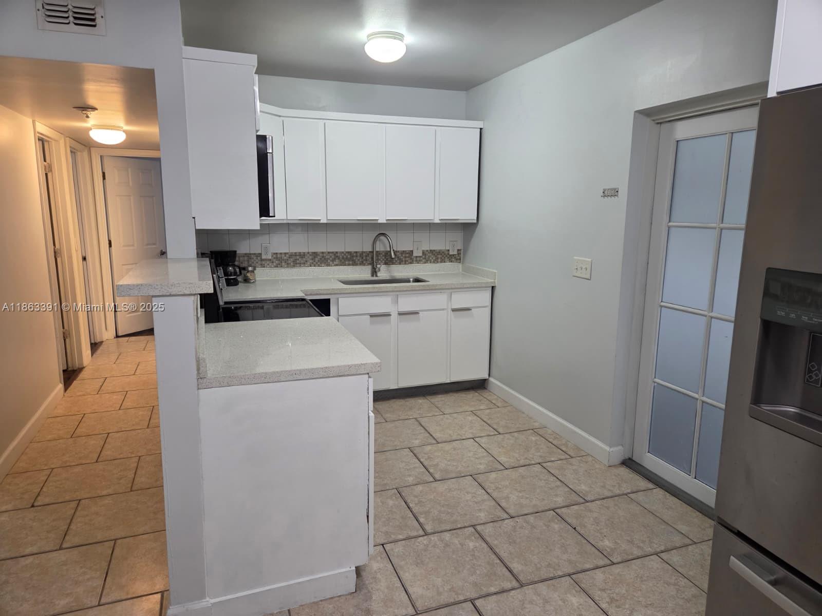 4351 Northeast 18th Avenue Pompano Beach, FL 33064 - Photo 6 of 18 a kitchen with a stove a refrigerator and a sink