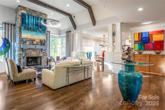 a living room with fireplace furniture and a large window