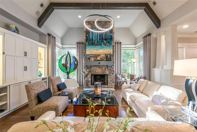 a living room with furniture fireplace and a large window
