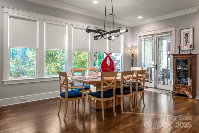 a view of a dining room and livingroom with furniture wooden floor a chandelier