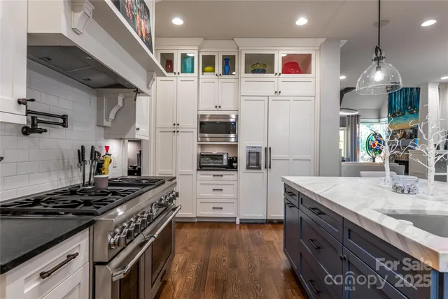 a kitchen with stainless steel appliances a stove a sink and a refrigerator